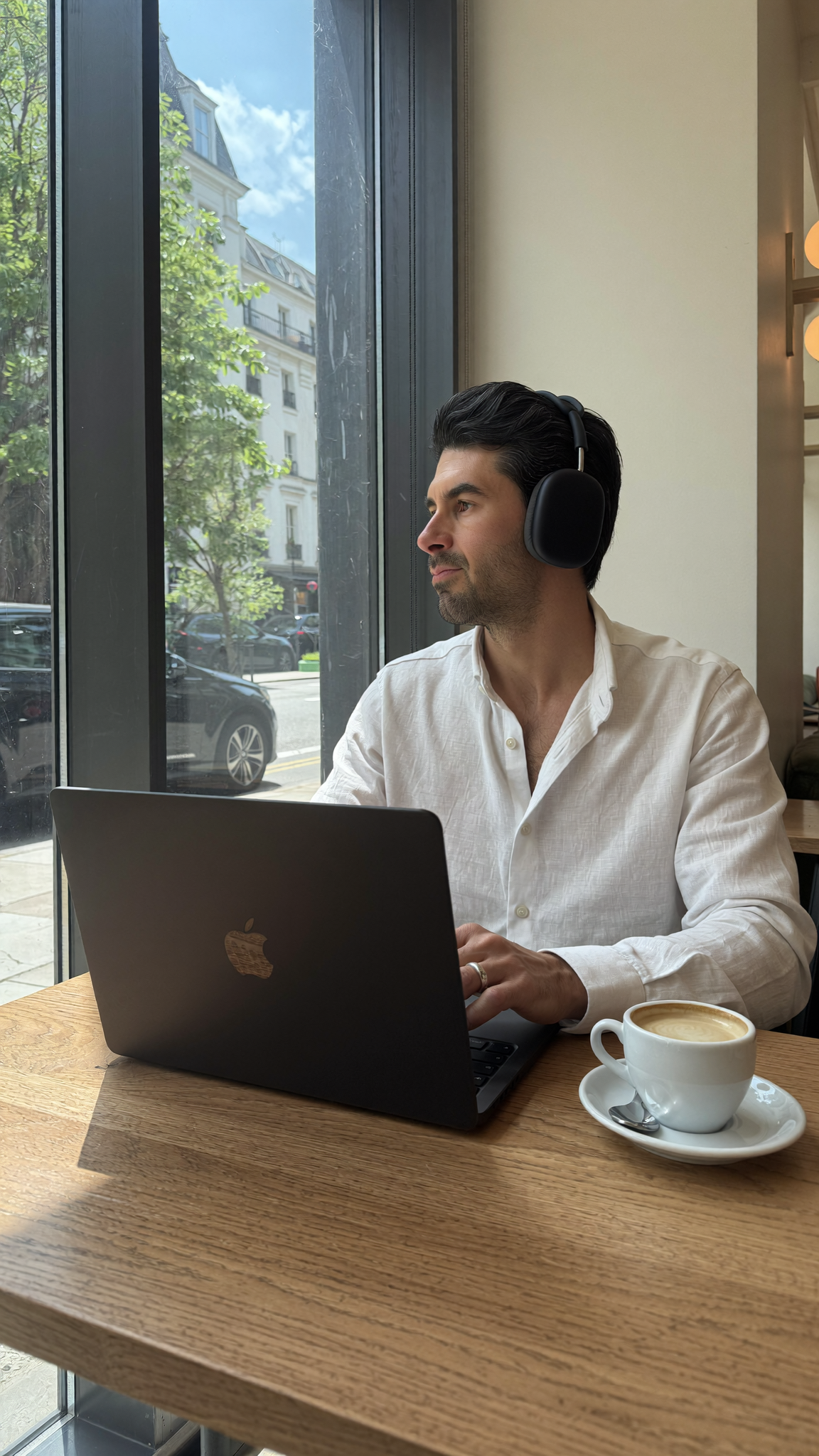 DTC operator working on a MacBook in a cafe while an AI agent builds Klaviyo email flows in the background